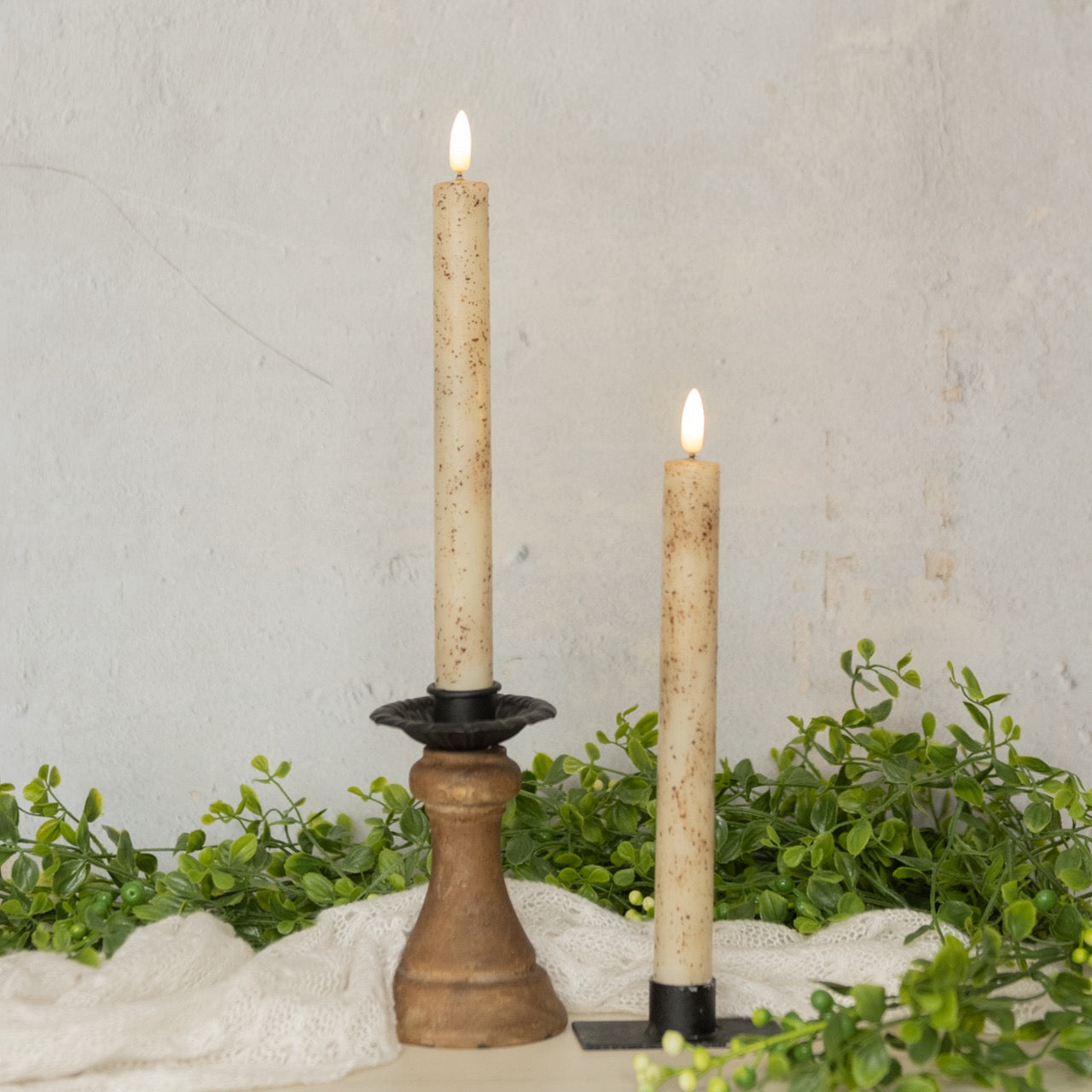 Elegant 3D flame cream taper candles, 9.5 inches tall, displayed in decorative holders. These flameless candles add warmth and charm to any setting.