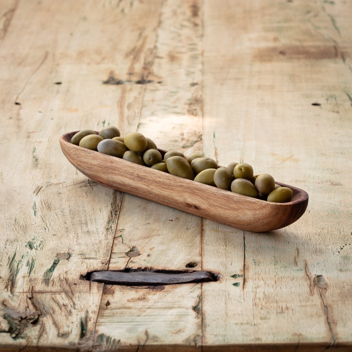 Wooden olive tray filled with green olives, ideal for serving alongside meats and cheeses. A stylish addition to any charcuterie spread.