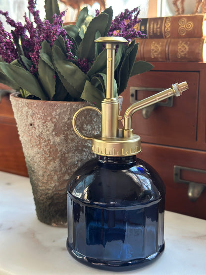 Glass mister in blue with a brass pump, ideal for watering plants with a fine mist. Stylish and water-saving design for indoor gardening.
