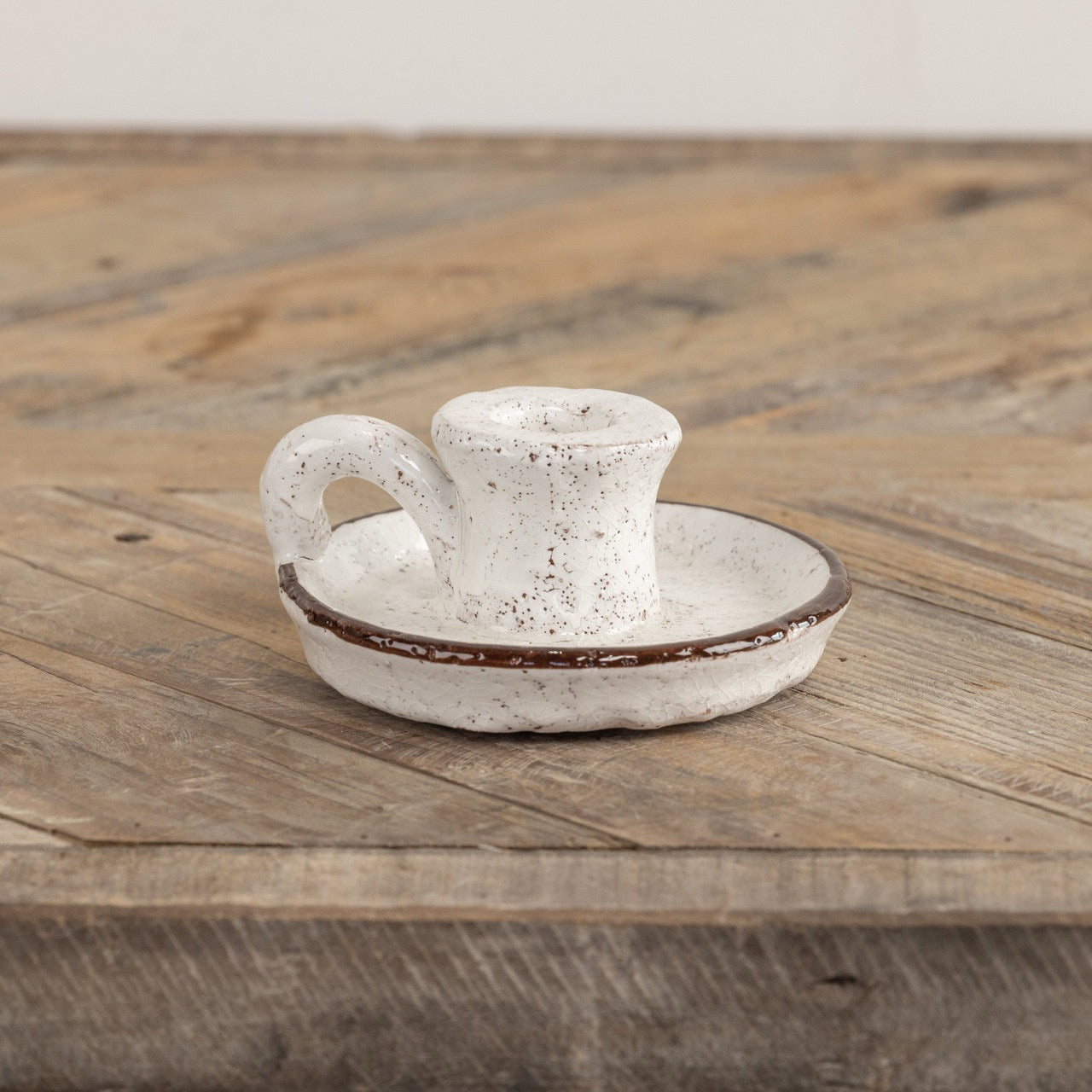 Brown and white terracotta taper candle holder with handle, featuring a speckled finish and classic design. Perfect for rustic or farmhouse décor.