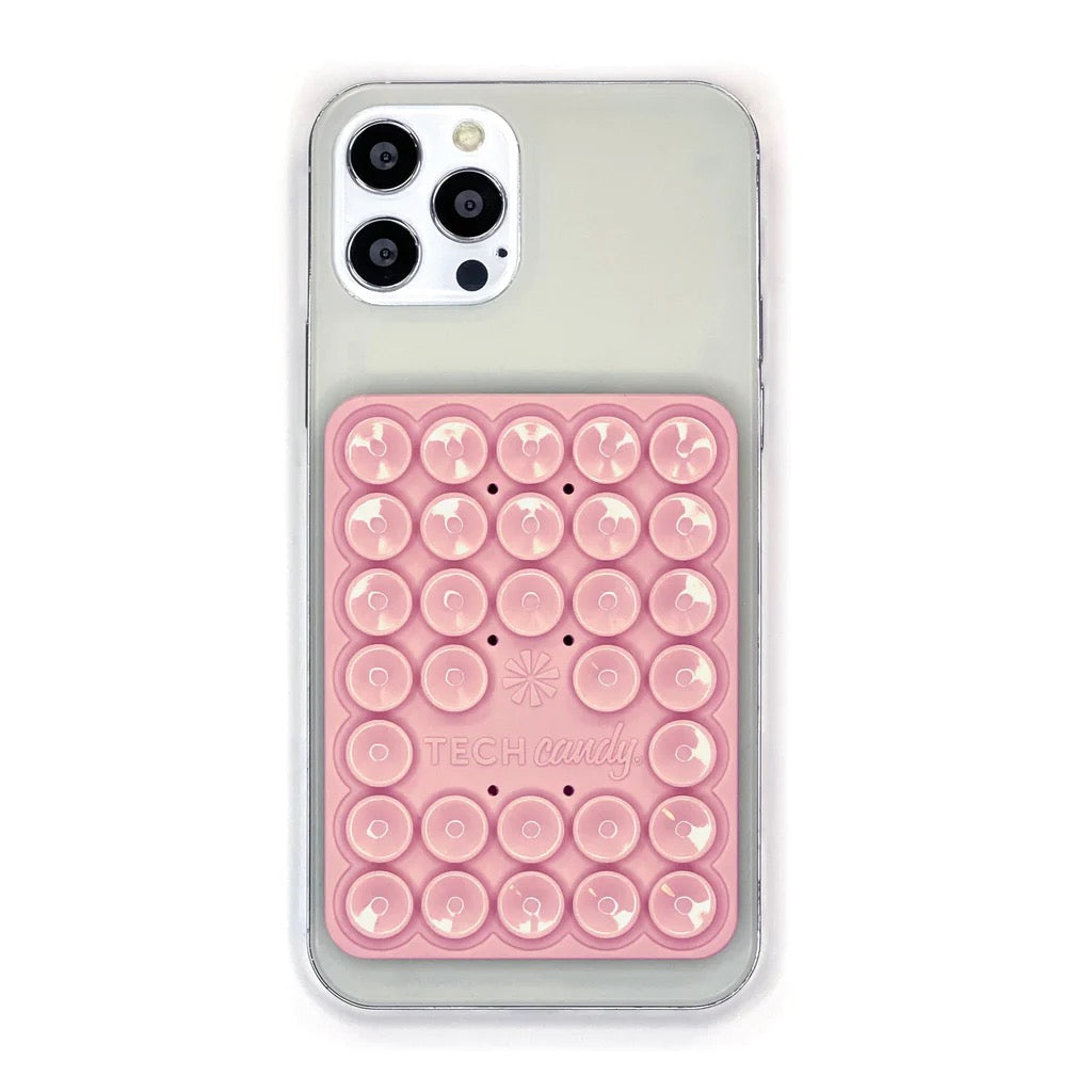 TECH CANDY STICK 'EM UP 2-SIDED PHONE SUCTION PAD in pink affixed to a smartphone. Provides strong suction for stability and convenience.