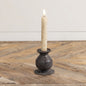 3.5-inch Jasper taper candle holder with a rustic metal finish, holding a lit candle. A perfect accent for home décor with vintage charm.