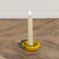 Lemon taper candle holder with a lit candle, featuring a rustic yellow metal design with green leaves, adding a citrus-inspired charm to home decor.