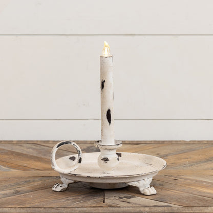 White metal dish taper candle holder with an antique distressed look, clawfoot legs, and a side handle. Ideal for farmhouse and rustic home decor.