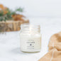 Antique Candle Co Cozy Cabin soy wax candle in an 8oz glass jar. A warm, woodsy scent perfect for a relaxing ambiance.