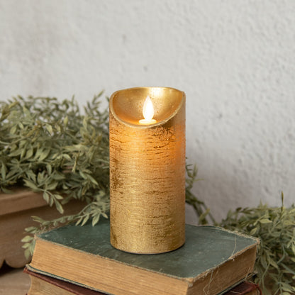 6-inch gold pillar candle with a moving flame, placed on vintage books. Ideal for elegant home decor and ambient lighting.