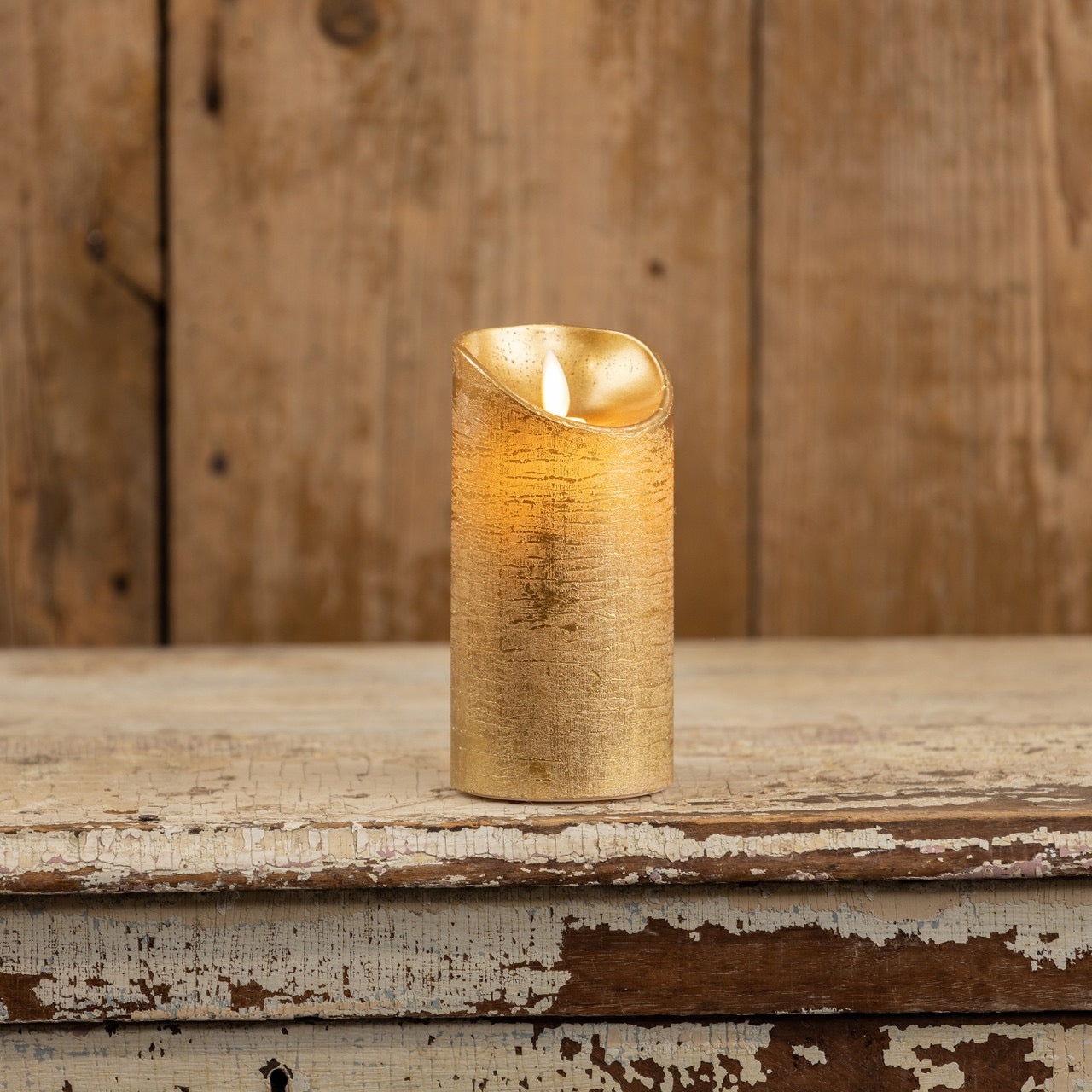 Gold pillar candle with moving flame, 6-inch size, featuring a realistic flickering effect. Perfect for home decor with a rustic wooden background.
