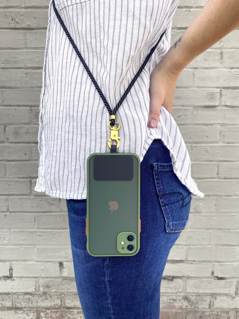 Person wearing TECH CANDY HOOKUP black lanyard attached to a green smartphone, showcasing hands-free convenience. Ideal for secure phone carrying.