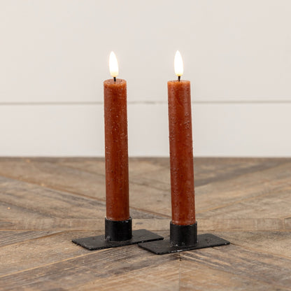 Pair of 3D Flame Bronze Taper Candles, 7.25 inches, with a flickering flameless glow on black metal holders. Elegant home decor accent.