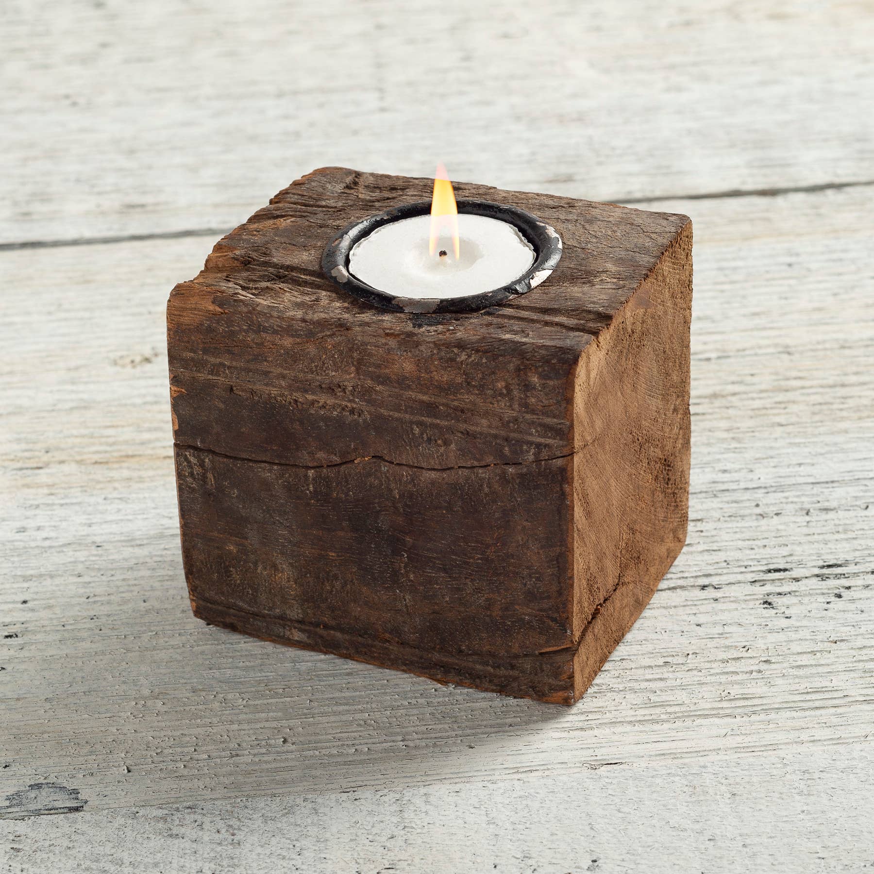 Square antique wood block candle holder with a lit tealight. Rustic home decor with recycled metal accents, perfect for adding warmth to any space.